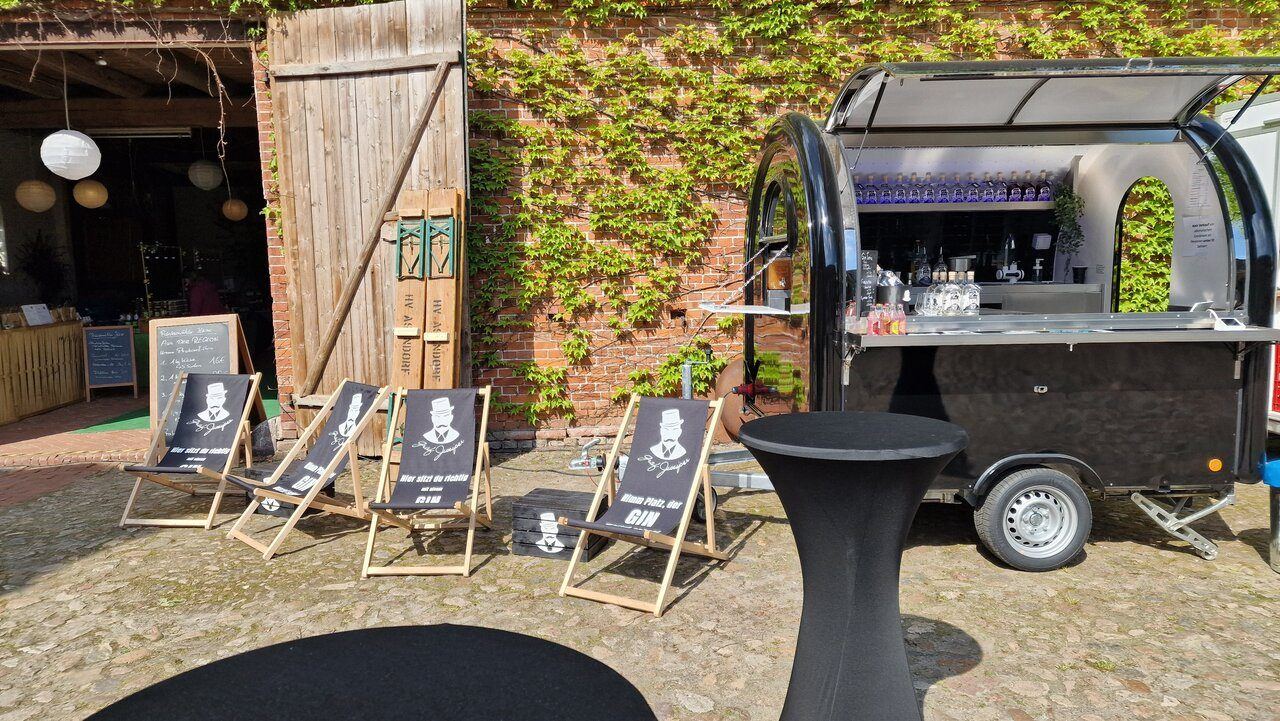 Schwarzer Retro-Foodtrailer als Cocktailbar vor einer Scheune